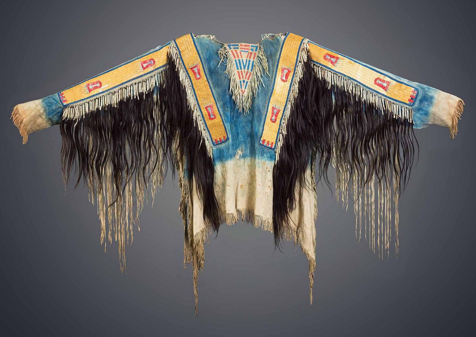 A Lakota quilled war shirt with human hair scalp locks. Masco collection.