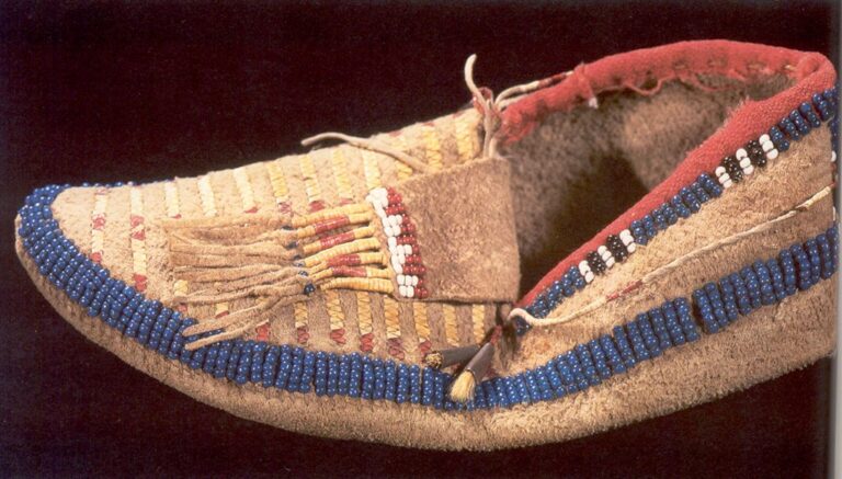 A pair of side seam moccasins, decorated with pony beads, and quillwork rows. Collected by G. K. Warren in Brule Lakota village after Ash Hollow battle, 1855.