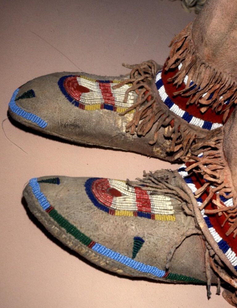 A pair of Crow side seam moccasins with a keyhole ornament embroidered with QWHH technique (double-bundle). Field museum.