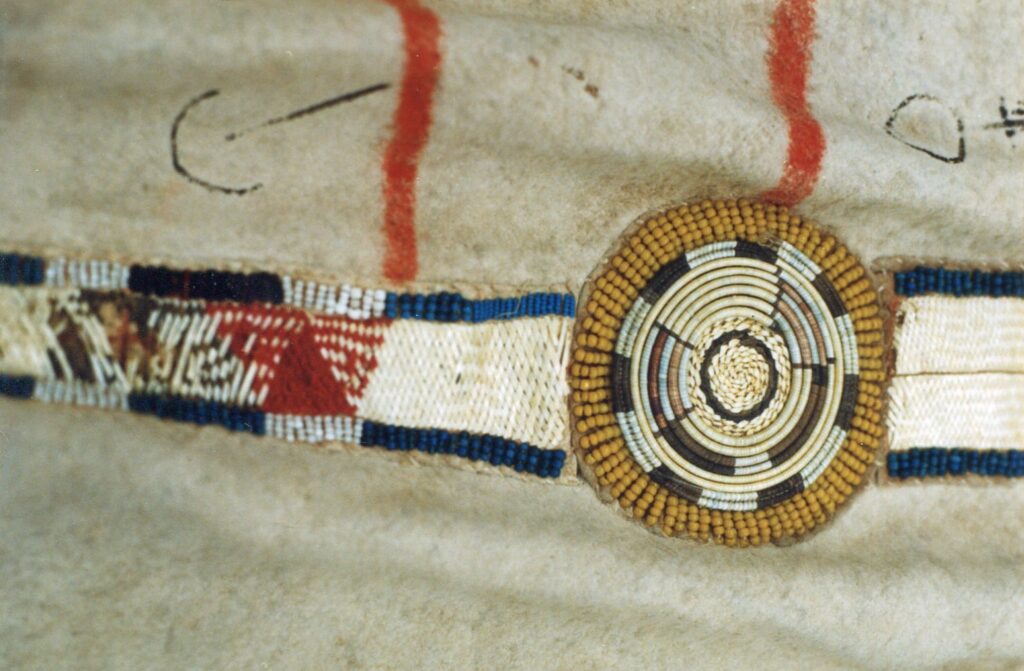 Detail of a buffalo robe with a decorative strip. The rosettes are embroidered with QWHH technique while the rectangular panels are embroidered with the plaited quillwork. Bernisches historisches museum.