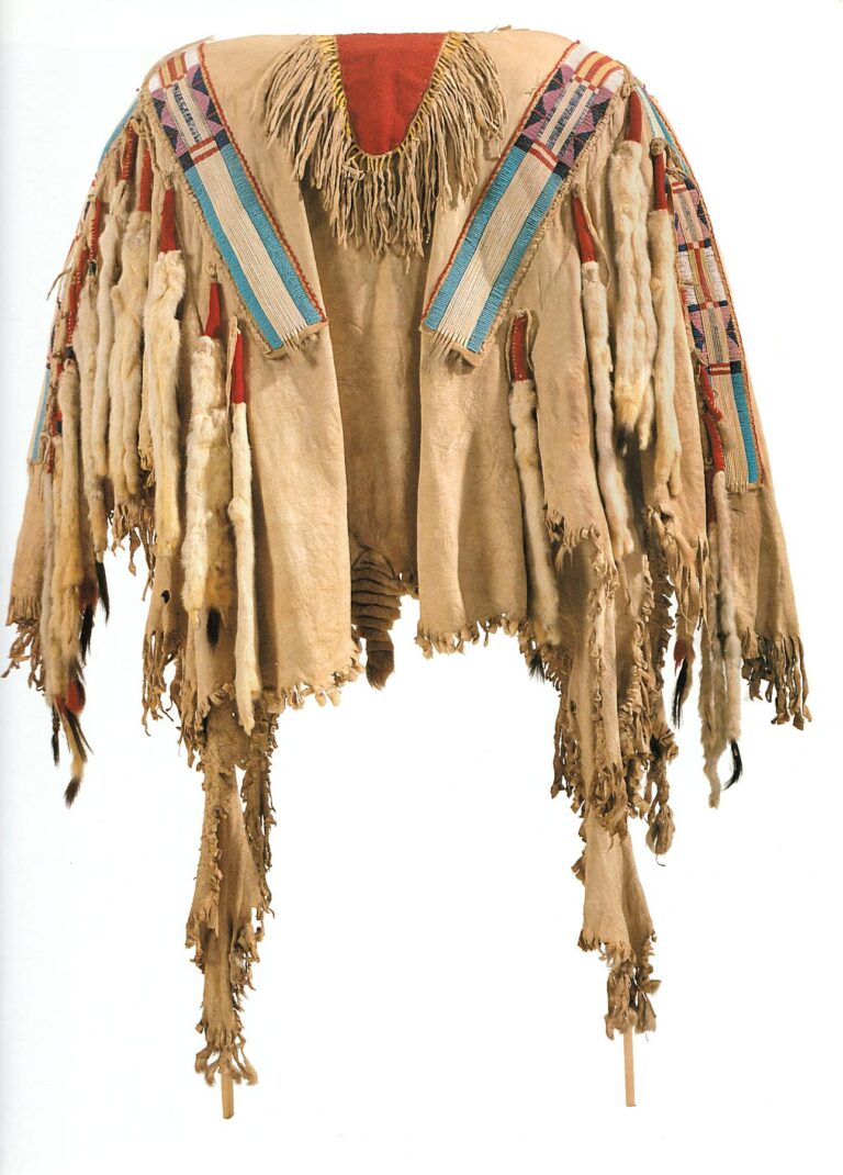 A war shirt (likely Crow). All four strips are embroidered using the QWHH technique and bordered with beads. NMAI.